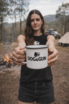 Girl holding large enamel mug while in the bush