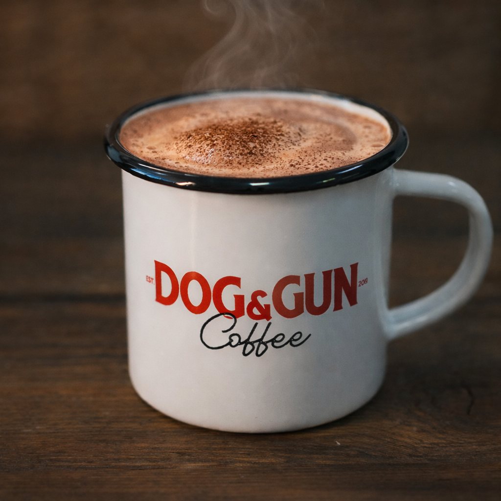 Steaming coffee in a 'Dog & Gun Coffee' mug on a wooden surface
